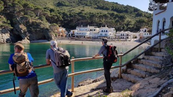 Wanderer blicken auf eine Bucht am Meer
