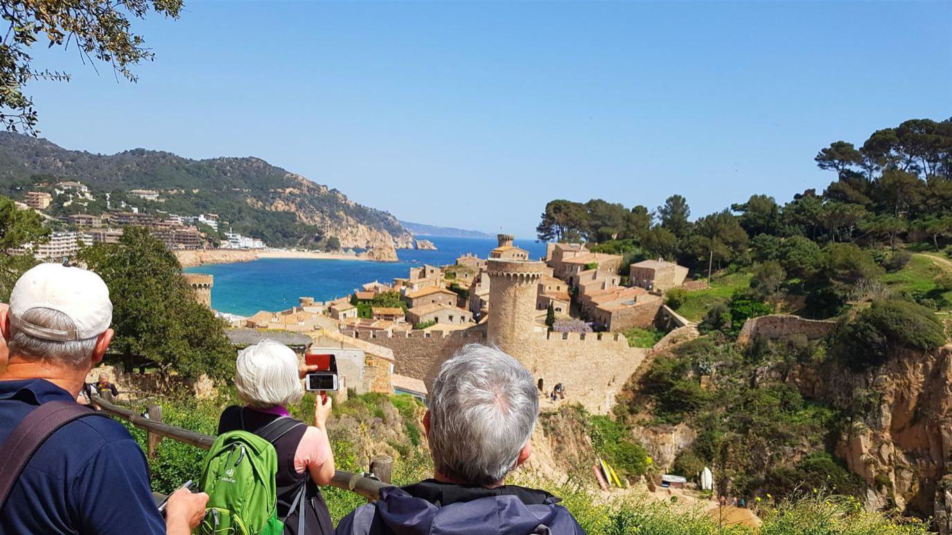 Leute stehen über der Burg von Tossa de Mar und schauen auf das Meer