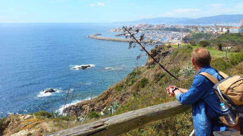 Wanderer blickt über das Meer mit Hafen